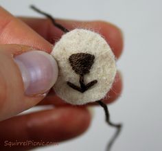 a person holding a needle with a small button on it