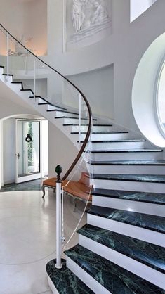 a spiral staircase with marble floors and white walls