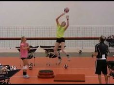 two women are playing volleyball on an indoor court