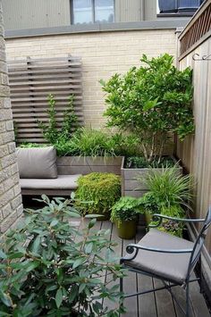 an outdoor patio with potted plants and seating on the decking area next to a brick building