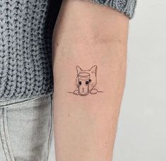 a small cat tattoo on the left inner arm