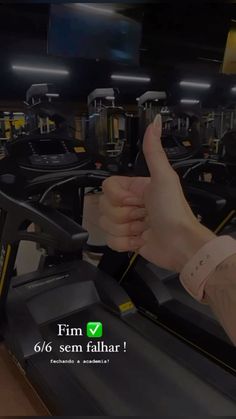 a person giving the thumbs up in a gym with treadmills and exercise equipment