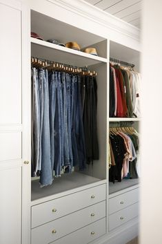 an organized closet with jeans hanging on the shelves and pants in the bottom drawers