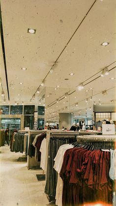 an empty clothing store with clothes on racks