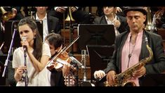 a man standing next to a woman on top of a stage with musical instruments in front of him