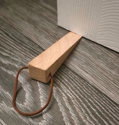 a piece of wood with a cord on the floor