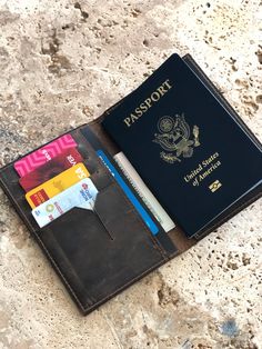 a passport, credit card and pen sitting on top of a counter next to a wallet