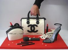 a handbag, purse, and makeup are on a red table with white background