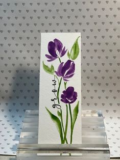 a card with purple flowers painted on it