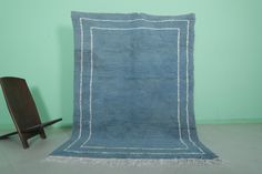 a blue rug sitting on top of a floor next to a wooden chair