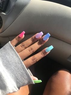 a person with multicolored nails sitting in a car