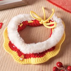 a red and yellow knitted headband next to berries