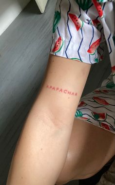 a woman with a watermelon tattoo on her arm and the word aragha written in red ink