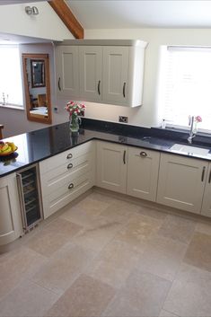 a kitchen with white cabinets and black counter tops