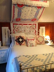 a bed with white and blue quilts on it