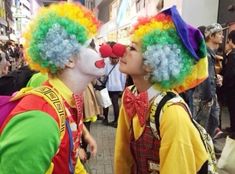 two clowns are kissing each other on the street