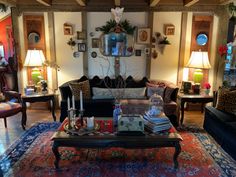 a living room filled with furniture and lots of pillows on top of a blue rug