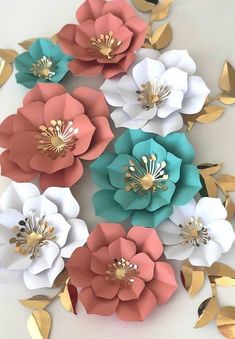 large paper flowers with gold leaves on the bottom and pink, white, blue, and green center