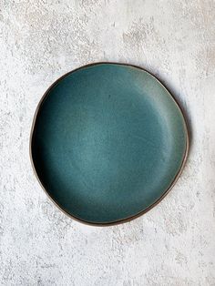 a green plate sitting on top of a white wall