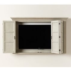 an entertainment center with shutters and a flat screen tv mounted on the wall above it