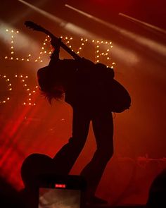 a person with a guitar in their hand on stage