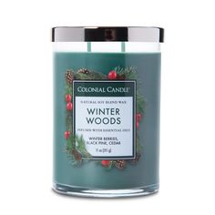 a candle that is sitting next to a white container with the words winter woods on it