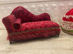 a red couch and chair sitting next to each other in front of a white wall