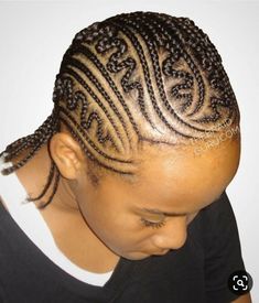 a woman with braids on her hair wearing a black t - shirt and looking down