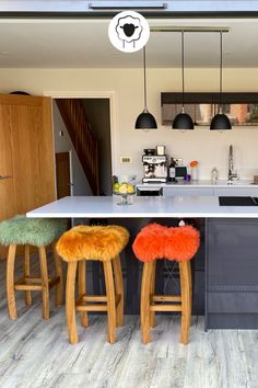 three stools sit in front of an island with two bar stools next to it