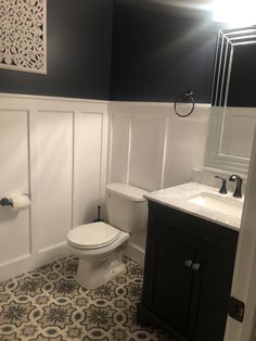 a white toilet sitting next to a sink in a bathroom