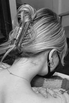 a woman with tattoos on her neck and behind her ear