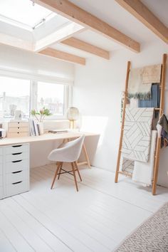 an attic office with white walls and wooden beams