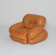 a brown leather reclining chair sitting on top of a white floor