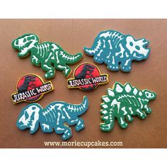 four different dinosaur shaped cookies on a table