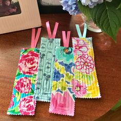 four pieces of fabric with pink and blue flowers on them sitting on a wooden table