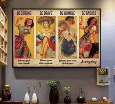 three vintage posters are hanging on the wall above a table with vases and other items