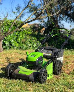 a green lawn mower sitting in the grass