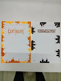 two notebooks that have been decorated with orange and black designs