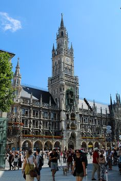 many people are walking around in front of a large building