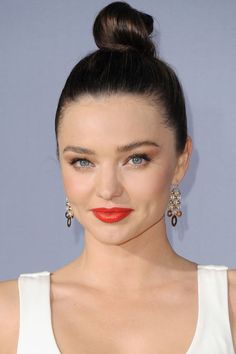 an image of a woman with red lipstick on her face and hair in a bun