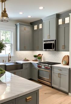 a kitchen with gray cabinets and white counter tops