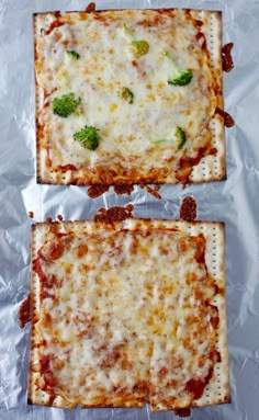 two square pizzas with cheese and broccoli sitting on aluminum foil lined up