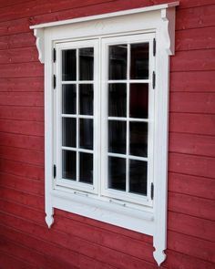 a red house with two windows and white trim