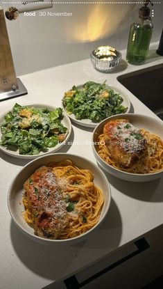 four bowls of food are sitting on the counter