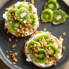 two pieces of bread topped with kiwi and nuts on top of a black plate