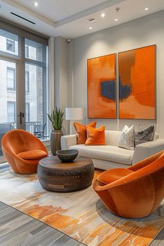 an orange and white living room with modern furniture in front of two large paintings on the wall