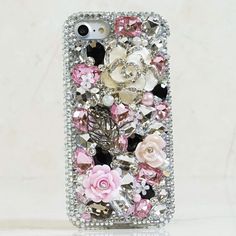 a cell phone case with flowers and jewels on the front, sitting on a white surface