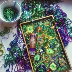 bead art is being displayed on a table next to scissors and other crafting supplies