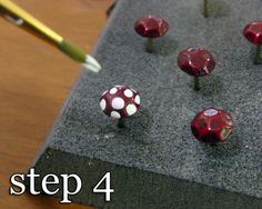 a group of red and white mushrooms sitting on top of a table next to a pencil