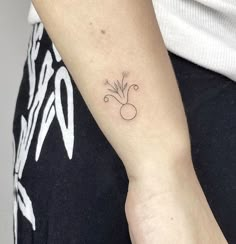 a woman's arm with a small flower tattoo on the left side of her arm